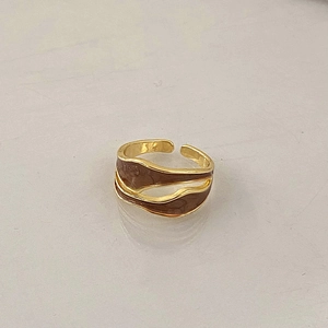Detailed macro view of the gold-plated double-layer wavy ring with brown enamel inlay