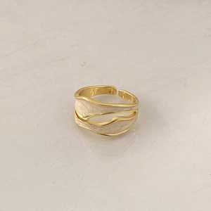 Detail view of gold layered wave ring featuring cream enamel inlay and minimalist design