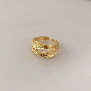 Macro detail of golden irregular lava texture and ripple design on an open ring