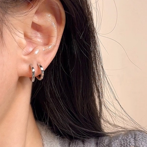 Gros plan de boucles d'oreilles anneaux argentées sur un modèle pour un look quotidien