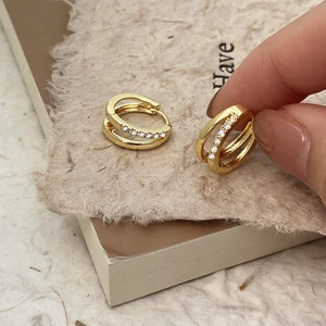 Macro detail of double-layer gold plated hoop earrings with micro-set cubic zirconia crystals