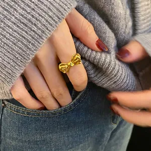 Elegant gold bow-shaped open ring with a polished finish shown on a model's finger