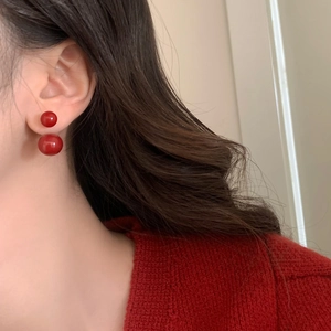 Close-up of bright red double pearl earrings shown on model with vintage French style
