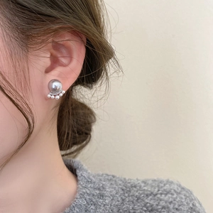 Detail of French cat claw pearl earrings with tiny crystals on an elegant woman