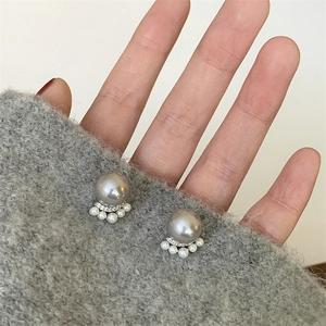 Elegant French style grey pearl earrings with crystal accents on a grey knit background