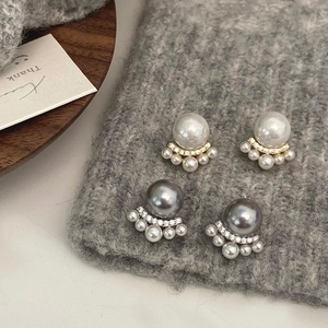 Close-up of French cat paw pearl earrings with diamond accents and gold-plated finish