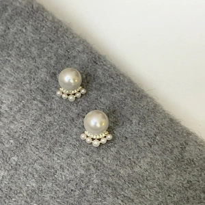 Detail of French style cat paw pearl earrings with gold base and zircon accents