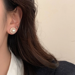 Detail of French vintage sunflower pearl earring with zircon stones on female model