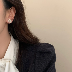 Detailed close-up of vintage-style pearl earrings set with gold-tone decorative edges