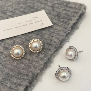 Macro detail of French style pearl earrings with gold and silver micro-set zircon frames