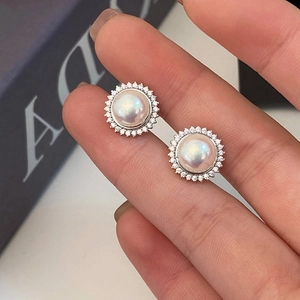 Macro detail of French style pearl earrings with sparkling zircon halo setting
