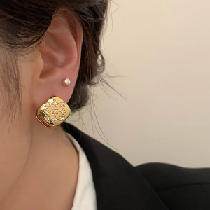 Elegant gold square earrings with star engraving and cubic zirconia on model