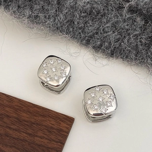 Detail view of silver square earrings with a 3x3 matrix of cubic zirconia stones