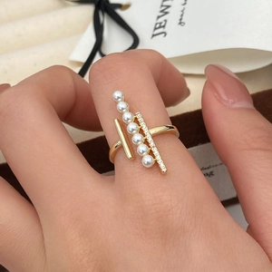 Macro view of adjustable gold ring featuring white pearls and shimmering zircon details