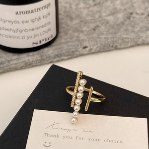 Detail of elegant gold-tone ring featuring parallel faux pearls and sparkling crystal rows