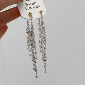 Elegant long tassel earrings featuring golden beads and heart-shaped silver chain charms