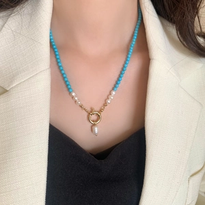 Natural freshwater pearl and turquoise necklace featuring a central golden spring clasp