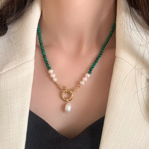 Close-up of freshwater pearls and turquoise beaded necklace with gold drop pearl pendant