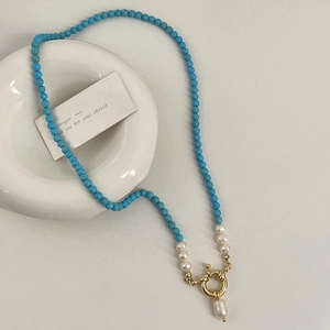 Detail of turquoise beaded necklace with freshwater pearls and baroque pendant