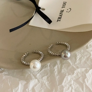 Detail of silver-plated open rings with pearls and sparkling cubic zirconia stones