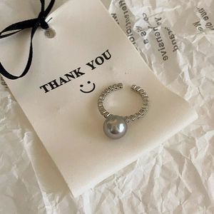 Macro detail of adjustable silver ring with dark grey pearl and pavé cubic zirconia