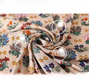 Close-up of floral print silk scarf with golden chain patterns and smooth texture