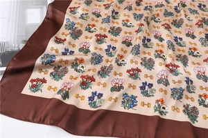 Detail of silk square scarf featuring floral prints and golden horsebit chain patterns
