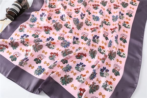 Detail of floral silk scarf showing elegant horsebit pattern and smooth satin texture