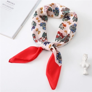 Elegant floral silk scarf with red borders and golden horsebit patterns in bow display