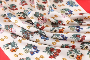 Detailed view of floral silk scarf featuring horsebit patterns on a red background