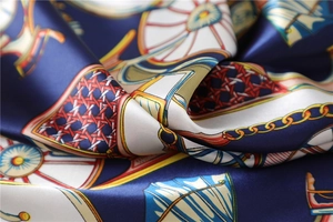 Macro detail of navy silk square scarf showing intricate vintage patterns and lustrous texture