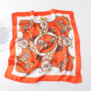 Detail of a square silk scarf with vintage orange horse carriage print on a magazine