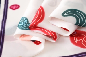 Macro shot of printed silk scarf showing artistic patterns and smooth glossy fabric texture