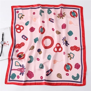Detailed flat lay of pink cartoon silk scarf with red edges and crown patterns