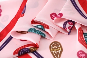 Detailed view of pink silk scarf featuring sweet ice cream and rainbow digital prints