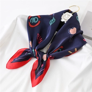 Navy blue silk square scarf with neon crown patterns and red border on white shirt