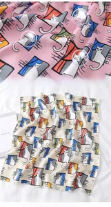 Detail of pink and beige satin silk scarves featuring cute cat and window pattern prints