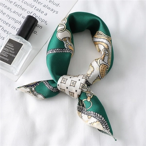 Detail of dark green satin scarf with gold chain pattern and elegant knot styling