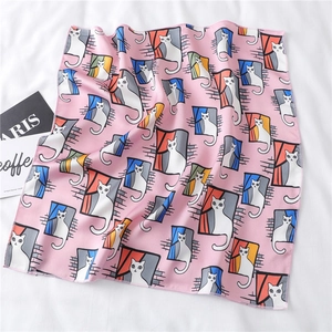 Detail of pink satin scarf showing cute cartoon cat patterns and high-density stitched edges