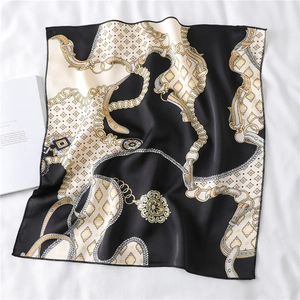 Detail of luxury chain print square silk scarf with golden belt motifs on soft fabric