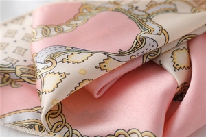 Detail of pink and cream satin scarf showing elegant gold chain patterns and smooth texture