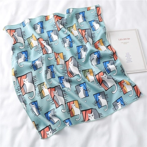 Detail of light blue silk square scarf with illustration of a cat by a window and hemmed edges