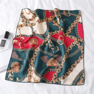 Close-up of square satin scarf featuring vintage gold chains and baroque mask patterns