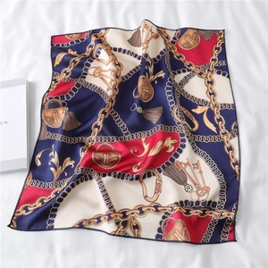 Detail of square silk scarf with golden chain, equestrian tassels and buckle pattern