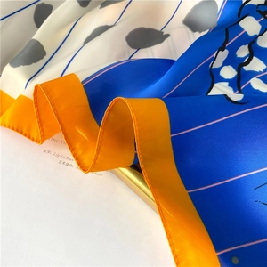 Macro detail of silk-like striped scarf showing smooth texture and rolled edge finish