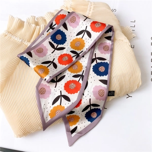 Detail of floral printed silk scarf with purple border and 100% polyester wash label