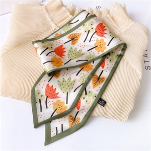Detail of floral printed silk scarf showing 100% polyester fabric and green hem