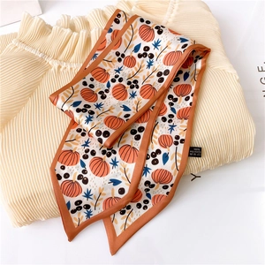 Detail of floral printed silk scarf with pumpkin pattern and 100% polyester label