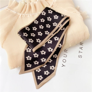 Close-up of floral print satin scarf with daisy patterns and beige piping on cream fabric
