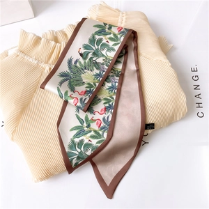 Detail of tropical print silk scarf showing flamingo patterns and 100% polyester care label